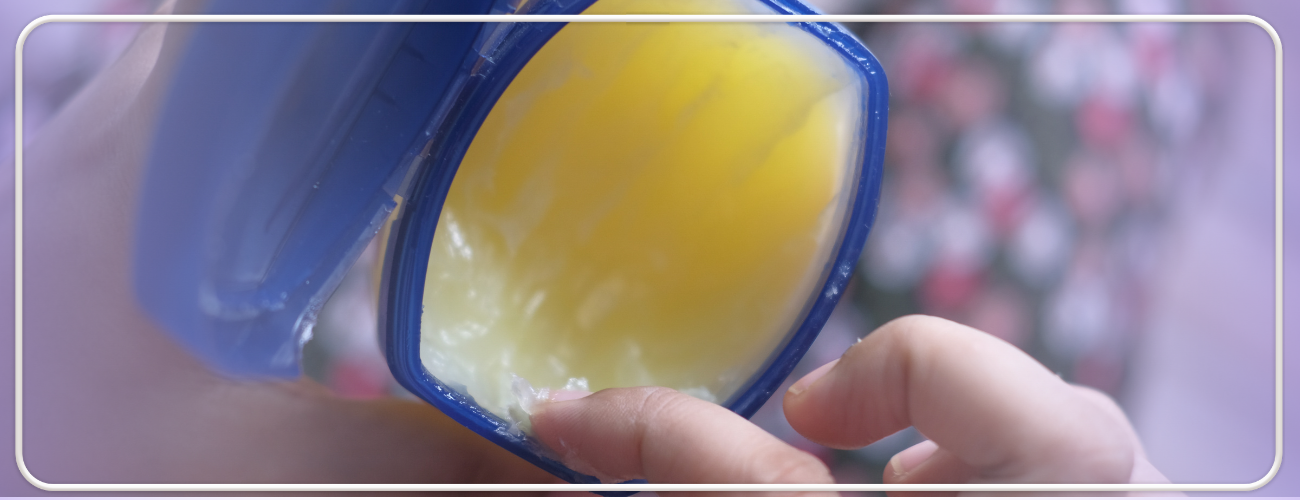 Fotografie de aproape a unei cutii de vaselină cosmetică, cu accent pe textura sa netedă și beneficiile pentru piele